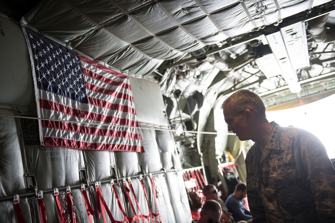 The vice chairman of the Joint Chiefs of Staff stand in the back of an aircraft.