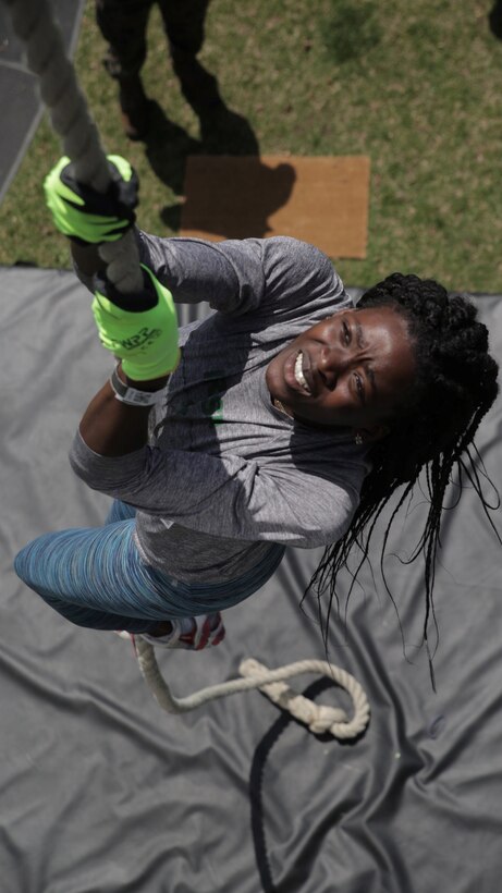 17-year-old Kadijah Nurudeen, a student athlete for Camden Catholic High School in Cherry Hill, New Jersey, participates in the Marine Corps Battles Won Challenge during the Penn Relays at Penn Park at the University of Pennsylvania campus in Philadelphia, April 26, 2018. Marines partnered with and attended the 124th Penn Relays to foster positive relationships with student athletes and coaches and to educate the track and field community on opportunities within the Marine Corps. This year, the Corps celebrates 100 years of women Marines, a milestone shown in the chance for female Marines to serve in any occupational specialty in the Corps, including all combat specialties. The Battles Won Challenge is a traveling obstacle course consisting of grip and strength bars, a cargo net climb, a rope climb, pull-ups, push-ups, sit-ups and a mental agility lab. (U.S. Marine Corps photo by LCpl. Naomi Marcom)