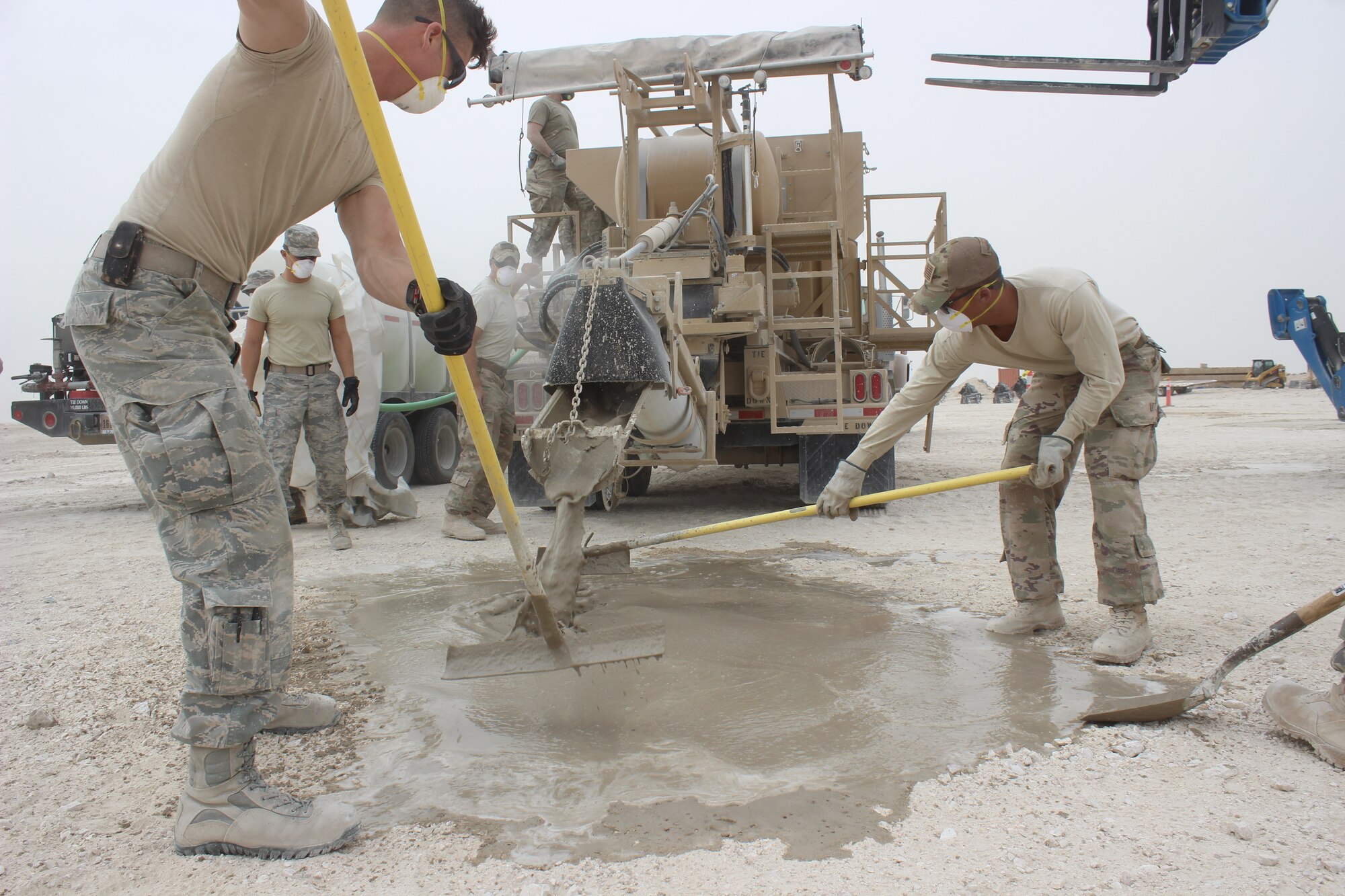 Civil engineers level concrete that caps a crater on a mock airfield at Al Udeid Air Base, Qatar on April 25, 2018. The machinery, a simplified volumetric mixer, expedites the time of mixing and placing concrete into craters on damaged airfields. Rapid Airfield Damage Recovery (RADR) is a new six-step concrete and asphalt repair process enhancing the ability of civil engineers to more rapidly repair airfields. Civil engineers can now guarantee repairs to full operational capability in a matter of hours. This is also the first time RADR has been utilized in AFCENT.(U.S. Air Force photo by Tech. Sgt. Arthur Mondale Wright)
