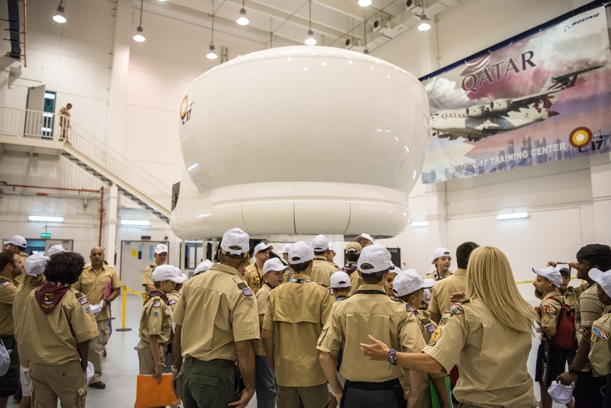 Boy Scouts prepare to use a C-17 Globemaster III aircraft flight simulator during a tour of Al Udeid Air Base, Qatar, April 20, 2018. The two-day visit, which was collaboratively coordinated by the 379th Air Expeditionary Wing and Qatar Emiri Air Force, provided the scouts a chance to earn merit badges, including the Aviation Merit Badge. (U.S. Air Force photo by Staff Sgt. Joshua Horton)