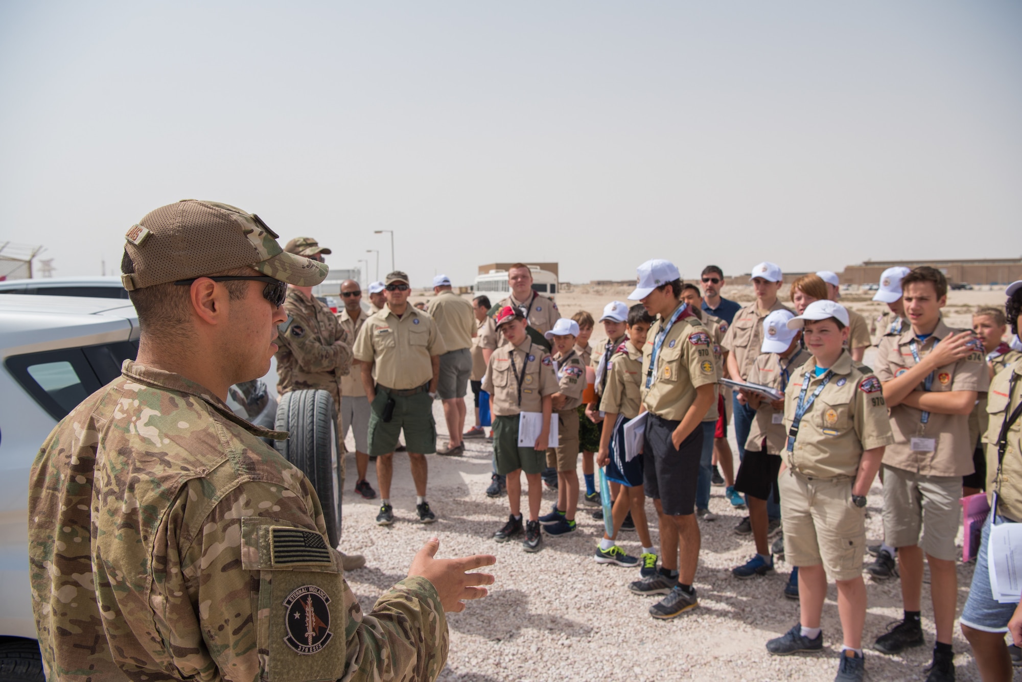 Staff Sgt. Marcus Lavalais, kennel master for the 379th Expeditionary Security Forces Squadron, briefs Boy Scouts from three different troops during a tour of Al Udeid Air Base, Qatar, April 21, 2018. The two-day visit, which was collaboratively coordinated by the 379th Air Expeditionary Wing and Qatar Emiri Air Force, provided the scouts a chance to earn merit badges, including the Aviation Merit Badge. (U.S. Air Force photo by Staff Sgt. Joshua Horton)