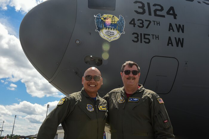 Col. Jimmy Canlas, 437th Airlift Wing commander, left, and Col. Gregory Gilmour, 315th Airlift Wing commmander, right, stand in front of the new nose art representing the 315th AW on the flightline during the rehearsal of the Air and Space Expo, April 27, 2018