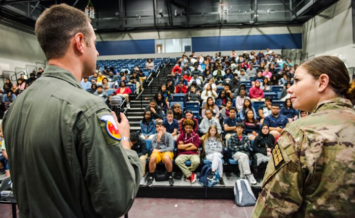 Master Sgt. Danny South, left, 16th Airlift Squadron loadmaster, and Airman 1st Class Kelly Walker, right, 1st Combat Camera Squadron photographer speak to students at R.B. Stall High School, April 27, 2018.