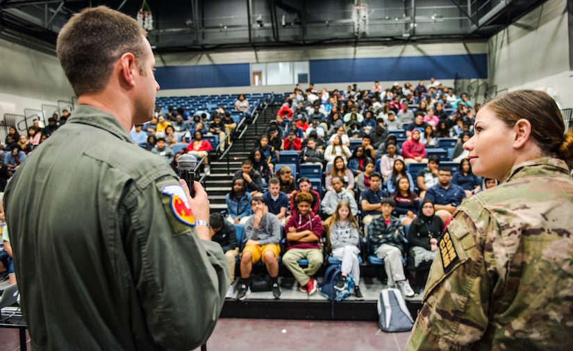 Master Sgt. Danny South, left, 16th Airlift Squadron loadmaster, and Airman 1st Class Kelly Walker, right, 1st Combat Camera Squadron photographer speak to students at R.B. Stall High School, April 27, 2018.