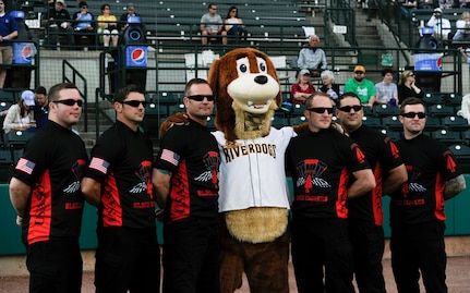 The U.S. Army Special Operations Command Black Daggers Parachute Demonstration Detachment have their photo taken with Charlie the RiverDog at the Joseph P. Riley, Jr. Park, April 26, 2018.