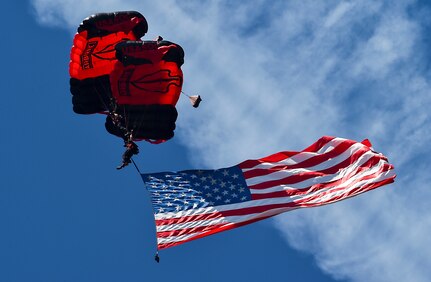 A U.S. Army Special Operations Command Black Daggers Parachute Demonstration Team member flies the American Flag during the National Anthem before the Air & Space Expo at Joint Base Charleston, S.C., April 28, 2018.