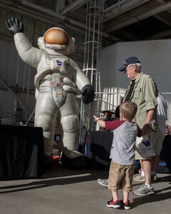 A young boy waves at an inflatible astronaut during the Joint Base Charleston Air and Space Expo at JB Charleston, S.C.  Apr 28, 2018.