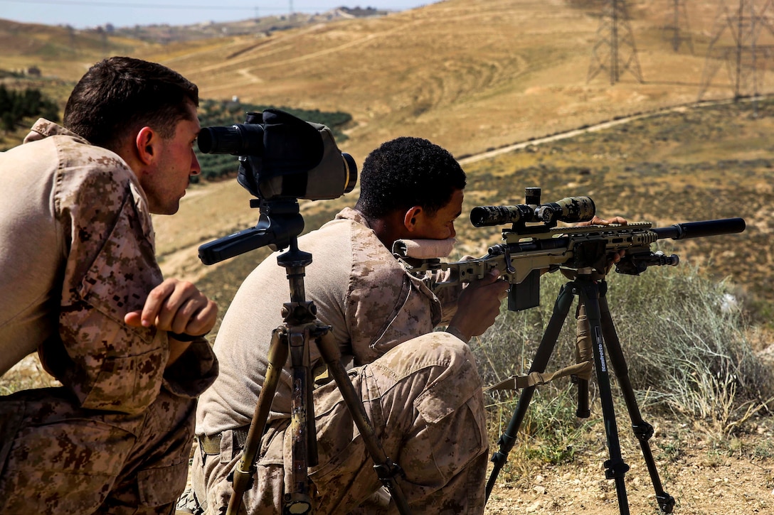 A Marine uses a tripod to steady his rifle.