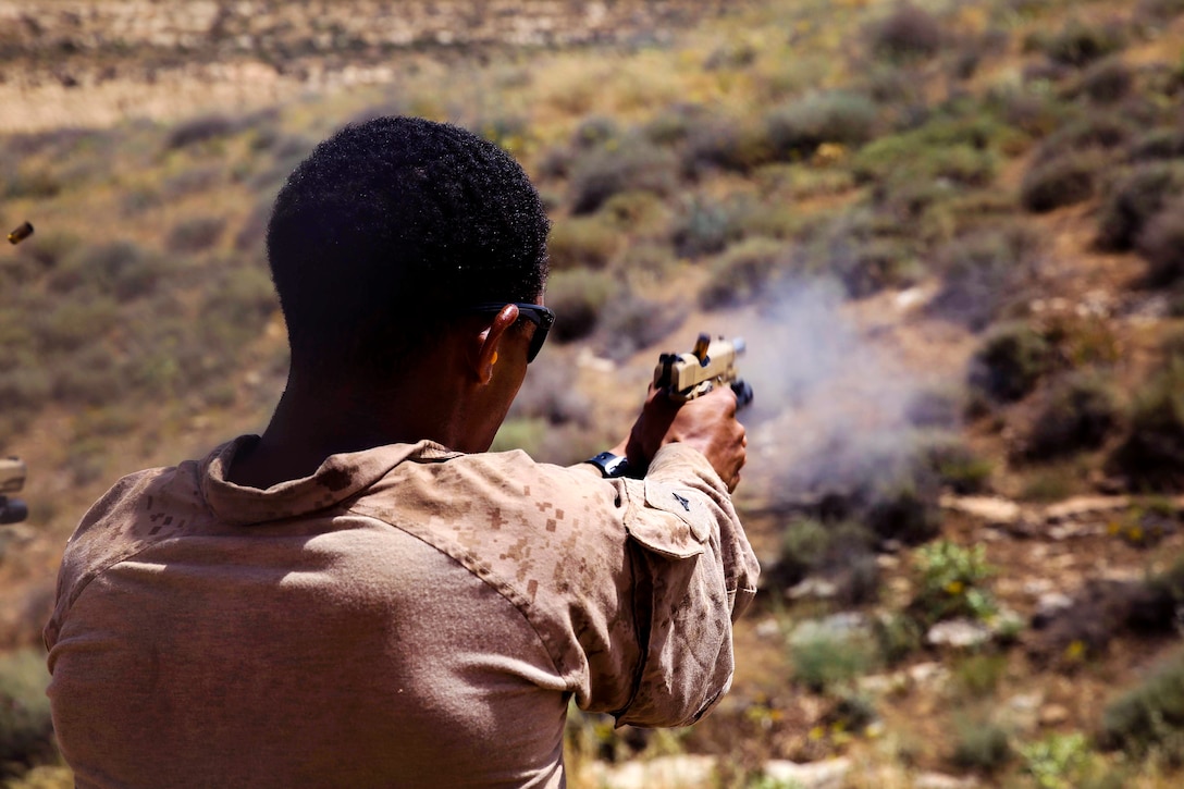 A Marine fires a pistol during shooting drills.