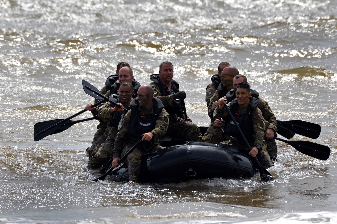 Soldiers paddle their combat raiding craft.
