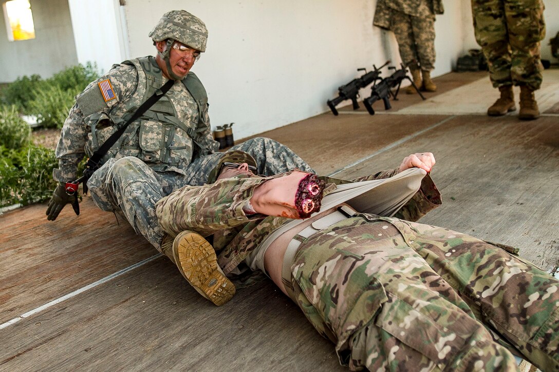 A soldier provides medical aid to a casualty.