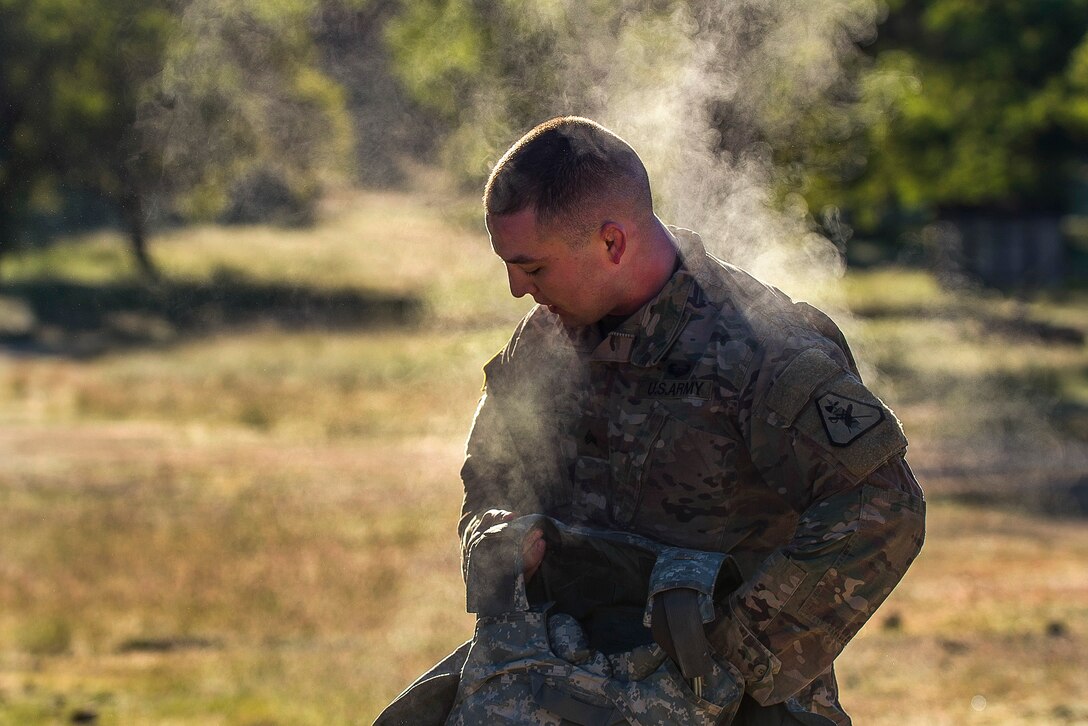 A soldier takes off his vest after a 10-mile ruck march.