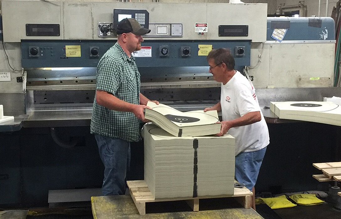 Document Services employees cutting out targets with the large paper cutter at Rock Island Arsenal.