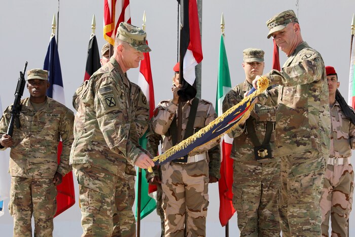 Two soldiers roll a flag.