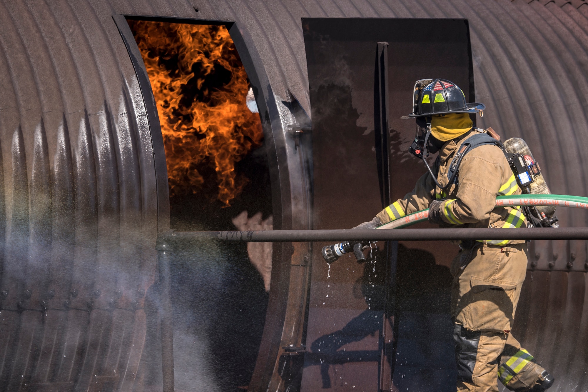 A firefighter from the Valdosta Fire Department (VFD) enters a simulated aircraft during live-fire training, April 25, 2018, at Moody Air Force Base, Ga. Firefighters from the 23d Civil Engineer Squadron and VFD participated in the training to gain more experience fighting aircraft fires and to work together as a cohesive team while still practicing proper and safe firefighting techniques. (U.S. Air Force photo by Airman Eugene Oliver)