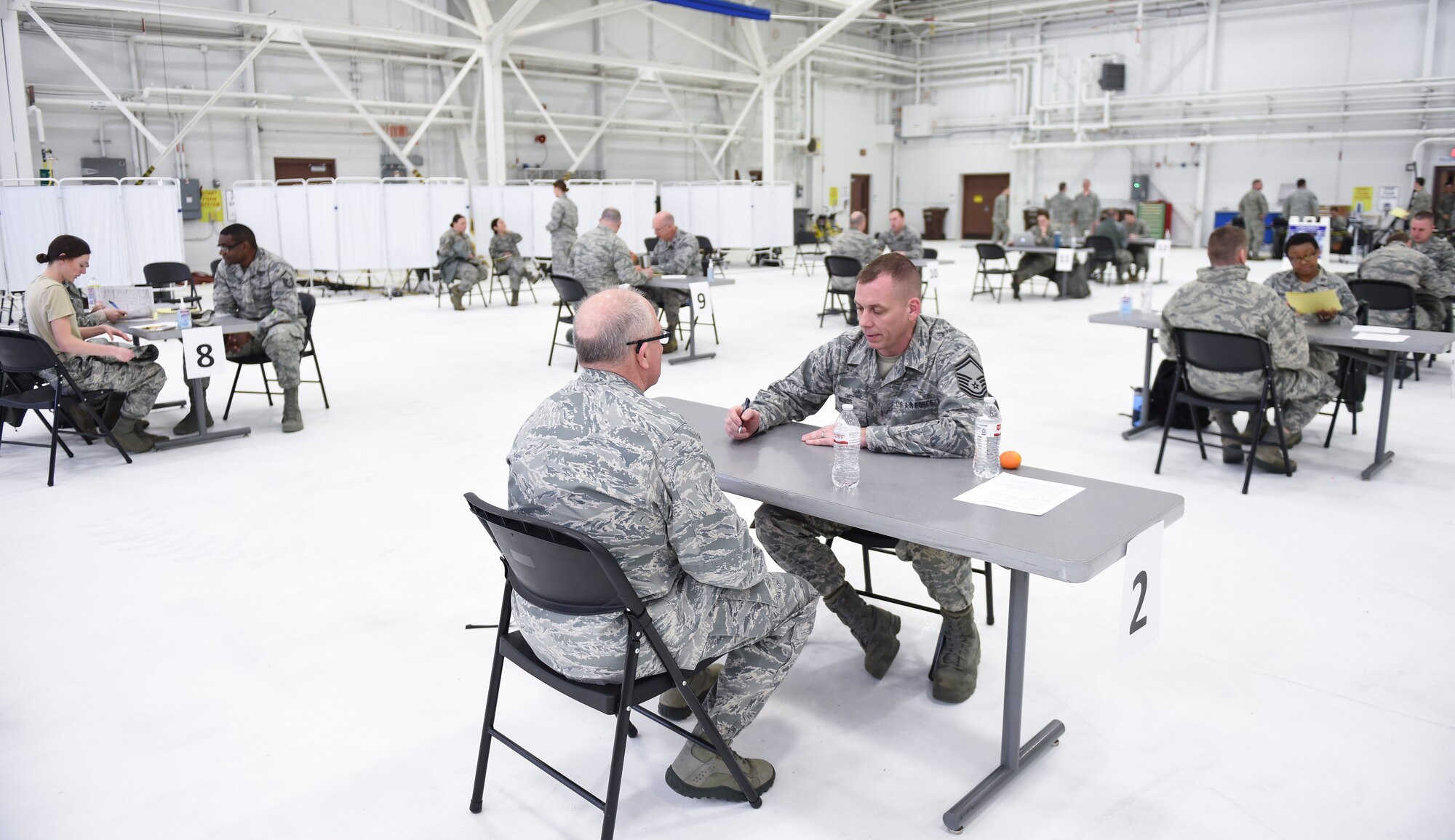U.S. Air Force Senior Master Sgt. Matthew Woods, 133rd Medical Group, talks to Col. Charlie Thigpen, left, deputy director for the Office of the Air Surgeon, about what is covered at the health history station in St. Paul, Minn., April 20, 2018.