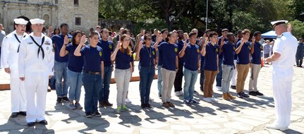 Capt. William Bindel, officer-in-charge, Navy Element, Joint Information Operations Warfare Center at Joint Base San Antonio–Lackland, administers the oath of enlistment to 20 future Sailors of Navy Recruiting District San Antonio during Navy Day at the Alamo April 26.  Bindel, a native of El Paso, Texas, also served as the keynote speaker during the event.