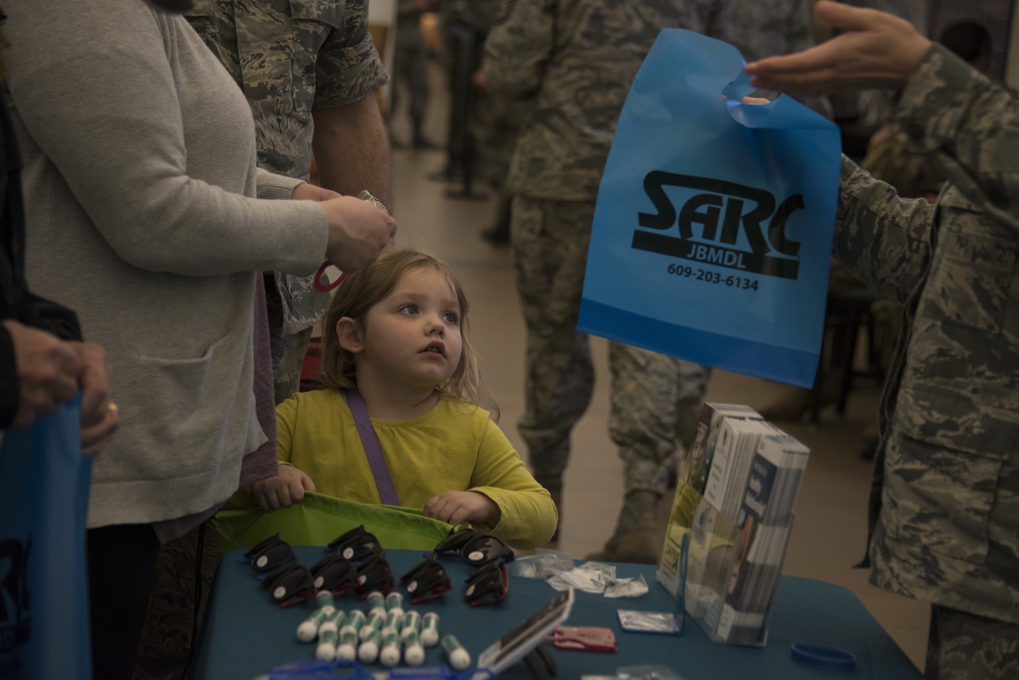 A child looks at a Sexual Assault Response Coordinator bag at an information booth during the Health and Wellness Fair on Joint Base McGuire-Dix-Lakehurst, N.J., April 18, 2018. Team members of various sexual assault awareness and prevention organizations educated service members and their families on the importance of warning signs and effects of sexual assault throughout the month of April. Educating the community helps people better understand how to help a victim and which organization to call depending on the situation. (U.S. Air Force photo by Airman Ariel Owings)