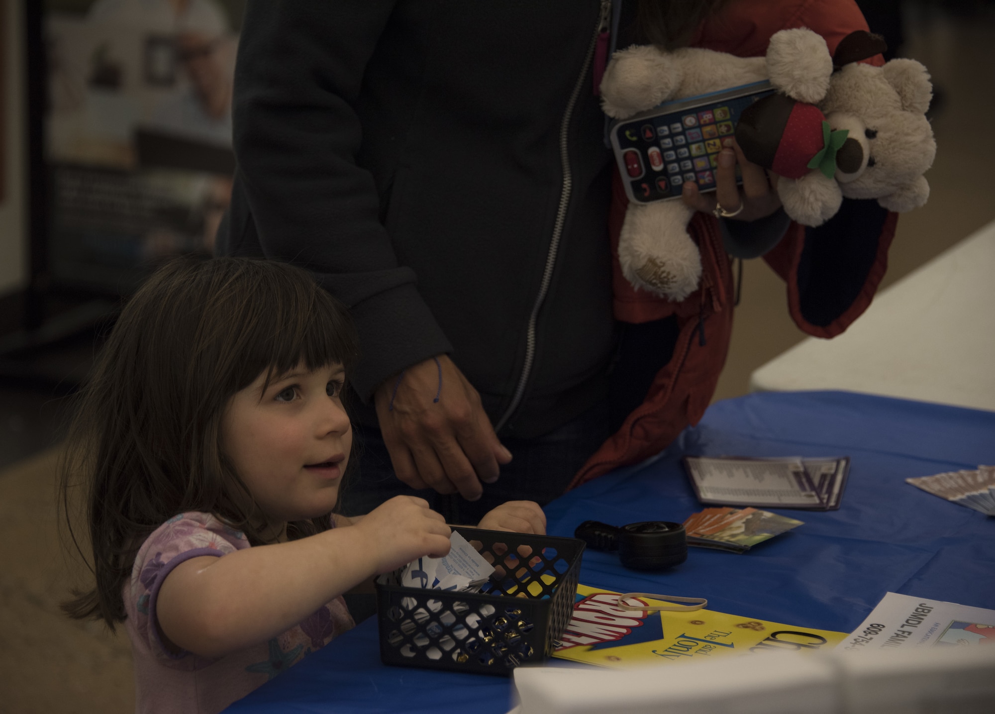 Abby, a military child who lives on Joint Base McGuire-Dix-Lakehurst, picks up a Sexual Assault Awareness and Prevention Month ribbon at the Health and Wellness Fair at The Exchange on Joint Base MDL, N.J., April 18, 2018. The fair was the third event during the month of April highlighting sexual assault awareness. The event featured information booths of different organizations to inform people of resources available and means of reporting incidents. (U.S. Air Force photo by Airman Ariel Owings)