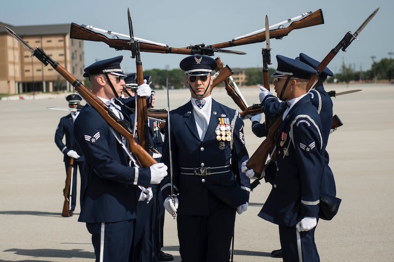 The U.S. Air Force Drill Team performs at the Basic Military Training Coin Ceremony at Joint Base San Antonio-Lackland, Texas, April 19, 2018. A standard Drill Team performance features a professionally choreographed sequence of show-stopping weapon maneuvers, precise tosses, complex weapon exchanges, and a walk through the gauntlet of spinning weapons. (U.S. Air Force photo by Airman 1st Class Dillon Parker)