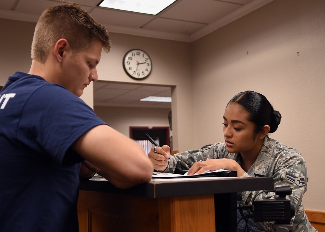 Air Force Airman 1st Class Rosa Vittori, a personnel specialist with the Texas Air National Guard’s 149th Fighter Wing, processes paperwork for Zach Pratka, a member of the wing's student flight at Joint Base San Antonio-Lackland, Texas, April 28, 2018. Texas Air National Guard photo by Airman 1st Class Katie Schultz