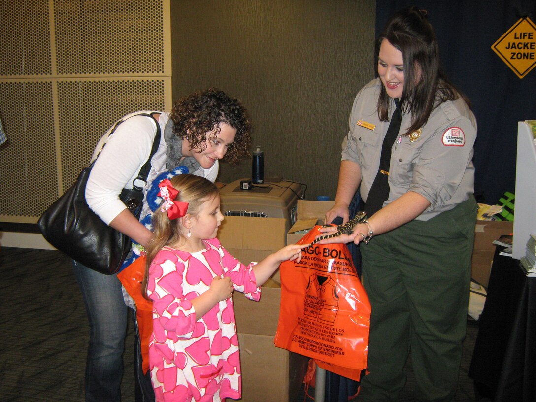 Natural Resource Specialist shows a young lady ACE the alligator at a water safety event.