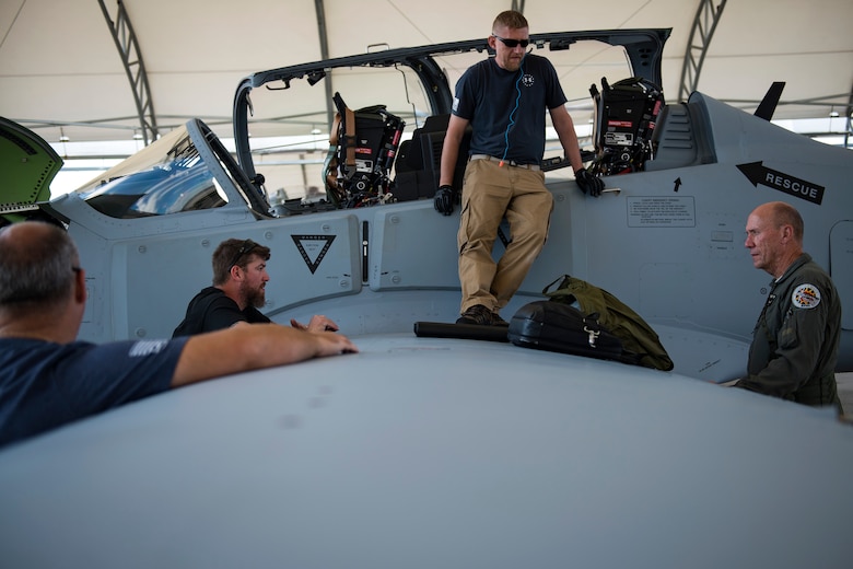 Contractors from the Sierra Nevada Corporation (SNC) perform a post-flight brief for an A-29 Super Tucano, April 24, 2018, at Moody Air Force Base, Ga. The 81st Fighter Squadron received the aircraft to help continue the Afghan light air support training mission, which ultimately provides Afghan pilots with the capabilities of finding, tracking, and attacking targets either on their own or in support of ground forces. The aircraft will be used by the Afghan Air Force for close-air attack, air interdiction, escort and armed reconnaissance. SNC is an American privately held electronic systems provider and systems integrator, and are the primary technicians and pilot instructors of the A-29s. (U.S. Air Force photo by Airman 1st Class Erick Requadt)