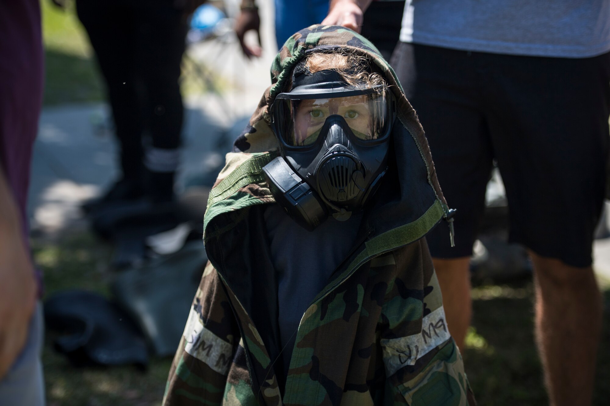 A participant tries on Mission Oriented Protective Posture or MOPP gear during the 2018 Kid’s Deployment Line, April 28, 2018, at Moody Air Force Base, Ga. The event allowed children the opportunity to experience what their parents go through while preparing to deploy. Children participated in obstacle courses, watched demonstrations and toured various aircraft and vehicles used by Airmen at Moody. (U.S. Air Force photo by Senior Airman Janiqua P. Robinson)