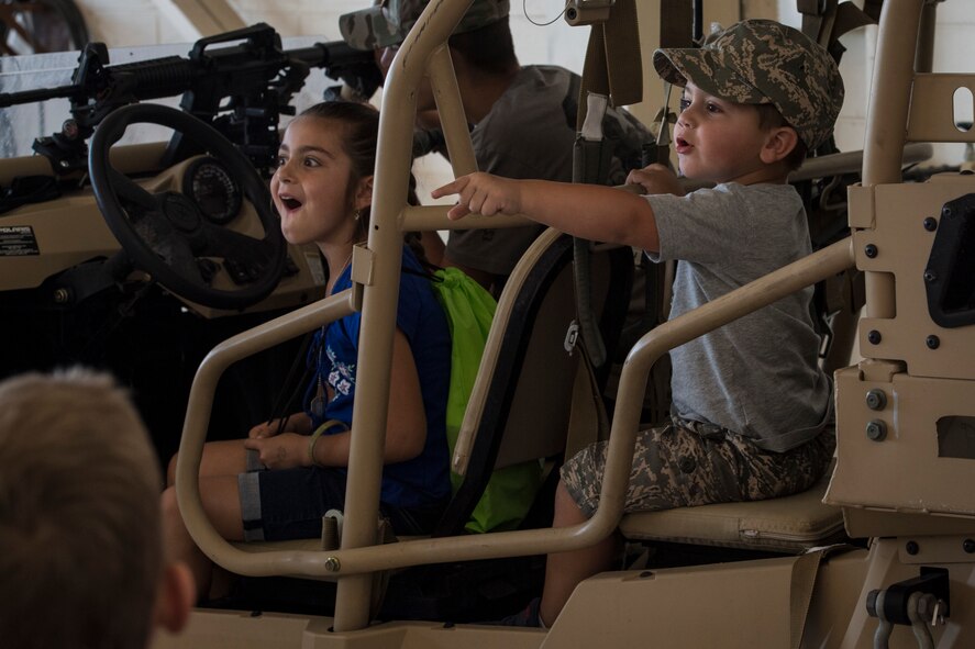 Participants sit in a military RZR all-terrain vehicle during the 2018 Kid’s Deployment Line, April 28, 2018, at Moody Air Force Base, Ga. The event allowed children the opportunity to experience what their parents go through while preparing to deploy. Children participated in obstacle courses, watched demonstrations and toured various aircraft and vehicles used by Airmen at Moody. (U.S. Air Force photo by Senior Airman Janiqua P. Robinson)