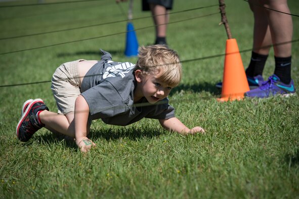 A participant crawls under a string obstacle during the 2018 Kid’s Deployment Line, April 28, 2018, at Moody Air Force Base, Ga. The event allowed children the opportunity to experience what their parents go through while preparing to deploy. Children participated in obstacle courses, watched demonstrations and toured various aircraft and vehicles used by Airmen at Moody. (U.S. Air Force photo by Senior Airman Janiqua P. Robinson)