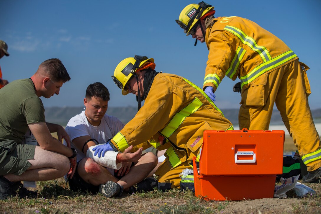 Lance Cpl. Jace Nguyen, an aviation ordnance systems technician with Headquarters and Headquarters Squadron, receives aid from first responders during exercise Semper Durus 18 on Marine Corps Base Camp Pendleton, Calif., April 25, 2018. Semper Durus exercises regional command and control during crisis situations to improve response procedures and limit impact while responding to possible terrorist activity.  (U.S. Marine Corps photo by Lance Cpl. Noah Rudash)