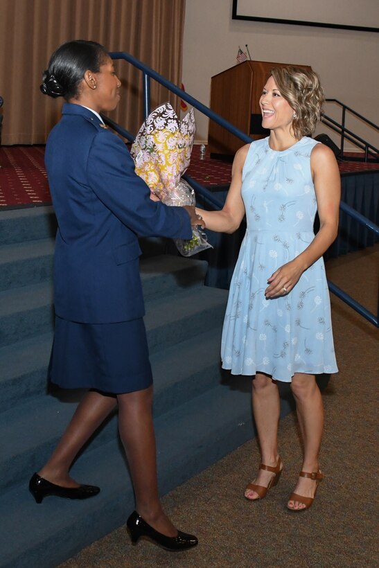 Maj. Jessica Sellers, commander of the 307th Force Support Squadron, presents flowers to Erin Liesveld during an Honorary Commander’s Induction Ceremony on Barksdale Air Force Base, La. April 29, 2018.