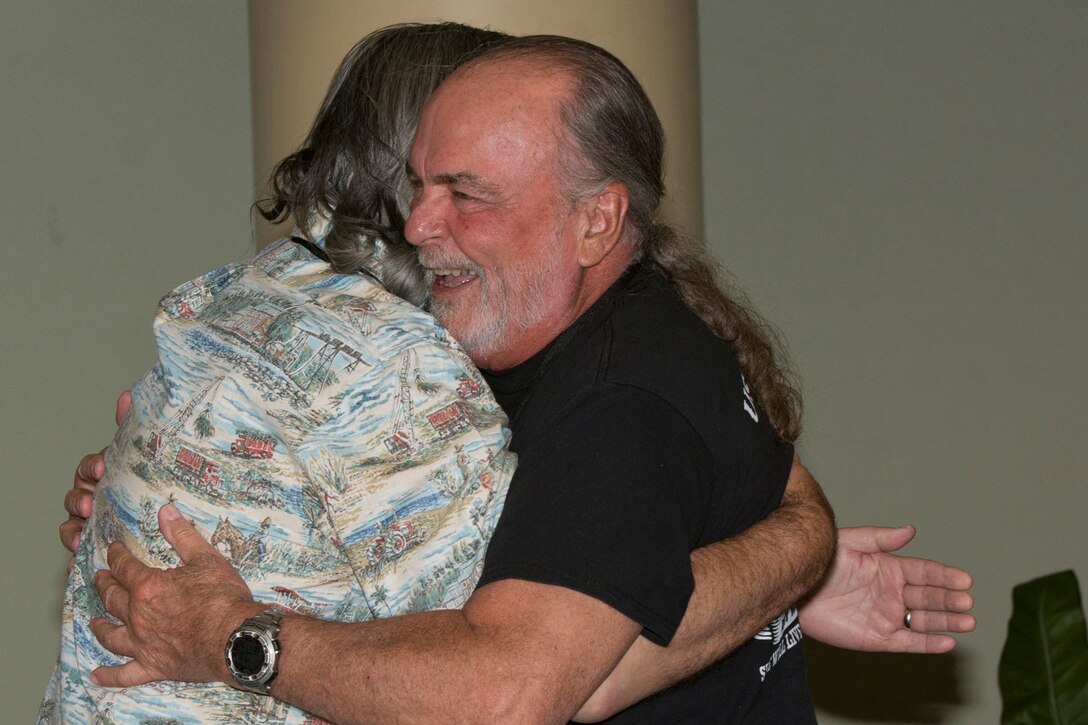 (Right) Retired U.S. Navy Electrician’s Mate Senior Chief Petty Officer (SS) James Drannan and Cmdr. (SS) Mike Urquhart, share a hug before dinner at the All Cavalla Reunion 2018, in Galveston, Texas, April 20, 2018.