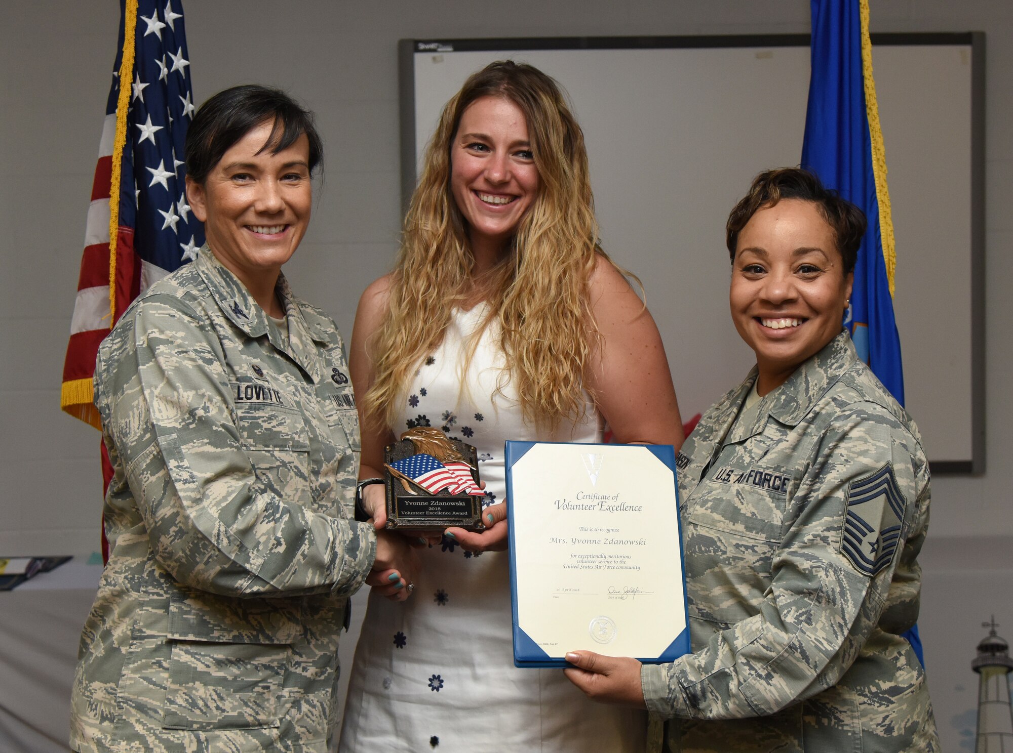U.S. Air Force Col. Debra Lovette, 81st Training Wing commander, and Chief Master Sgt. Tanya Johnson, 81st Diagnostic and Therapeutics Squadron superintendent, presents Yvonne Zdanowski, spouse of 2nd Lt. Paul Zdanowski, 81st Force Support Squadron resource management officer in charge, with a Volunteer Excellence certificate during the 2018 Volunteer Appreciation Ceremony at the Sablich Center at Keesler Air Force Base, Mississippi, April 26, 2018. The event recognized Keesler personnel, family members and retirees for their volunteer service in 2017. (U.S. Air Force photo by Kemberly Groue)