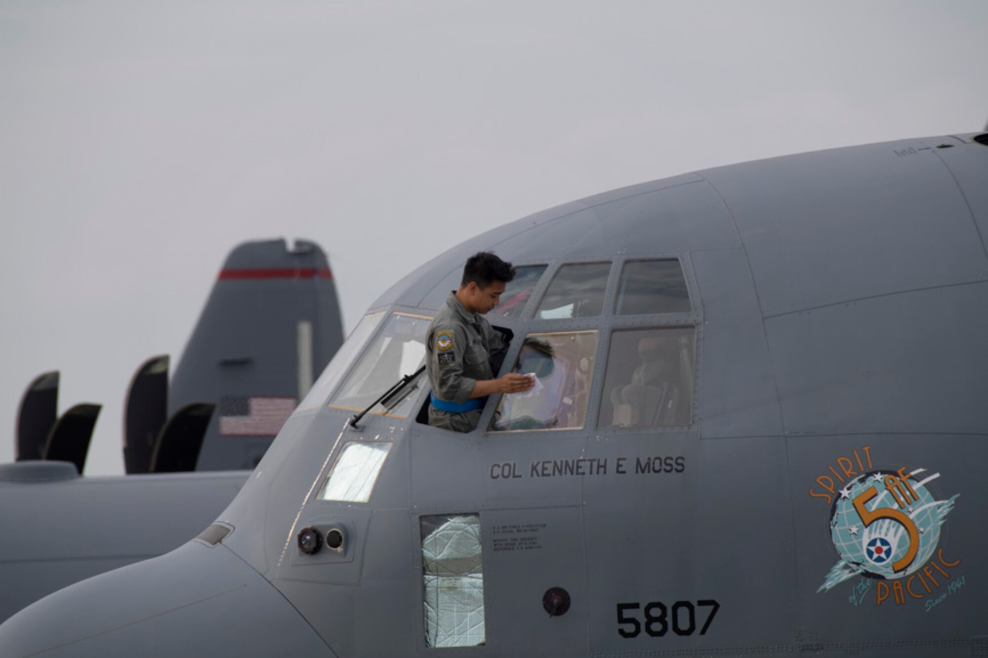 Airman 1st Class Justin Pesino, 374th Aircraft Maintenance Squadron crew chief, wipes down the windshield of a C-130J Super Hercules after a training mission at Yokota Air Base