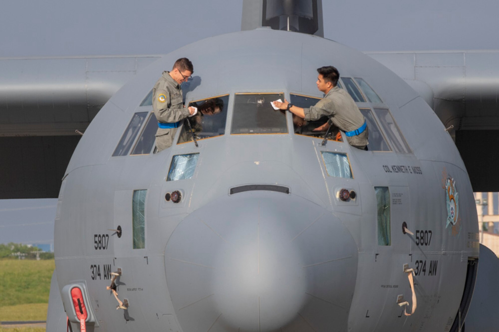 Airman 1st Class Michael Poyser, left, and Airman 1st Class Justin Pesino, both 374th Aircraft Maintenance Squadron crew chiefs, wipe down