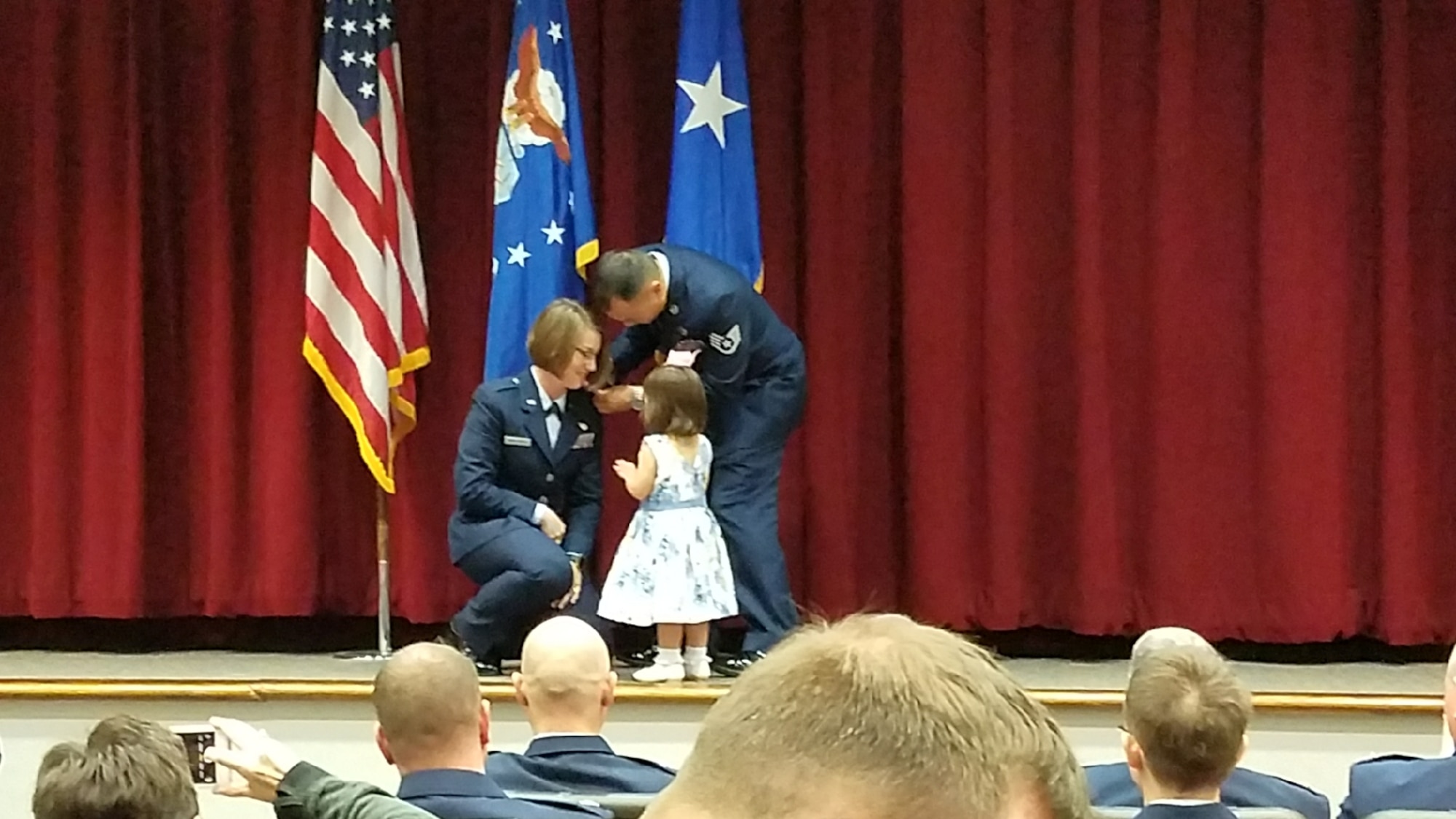 Vesper M. Yasahardja kneels as her daughter Aubrey, 2, and husband, Staff Sgt. Matius “Yoshi” Yasahardja, pin the rank of second lieutenant onto her shoulders March 16 at Maxwell Air Force Base, Alabama.