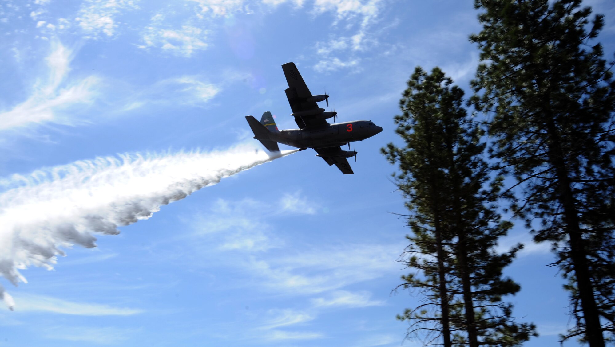 A C-130 Hercules aircraft equipped with a U.S. Department of Agriculture Forest Service Modular Airborne Fire Fighting System drops water over the Tahoe National Forest, California, April 26, 2018.