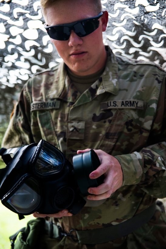 A soldier assembles a protective mask.