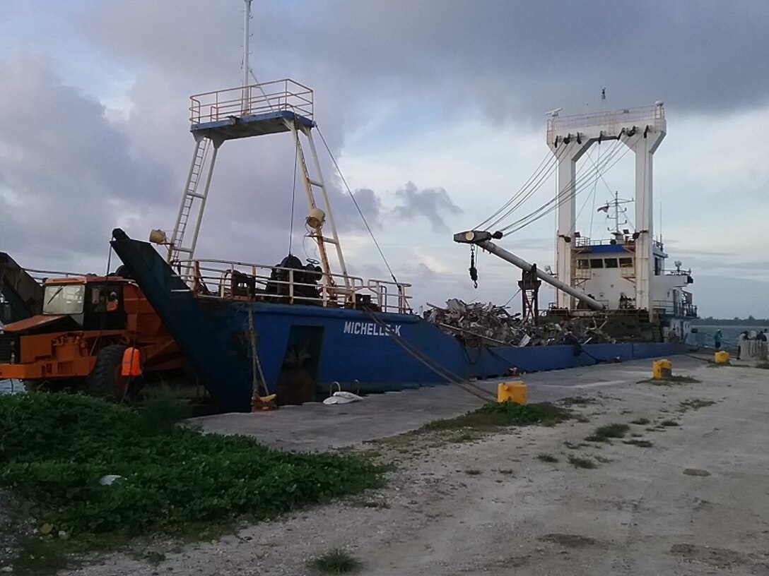 Truckers offload the scrap onto the first barge taking material away from Kwajalein Atoll.