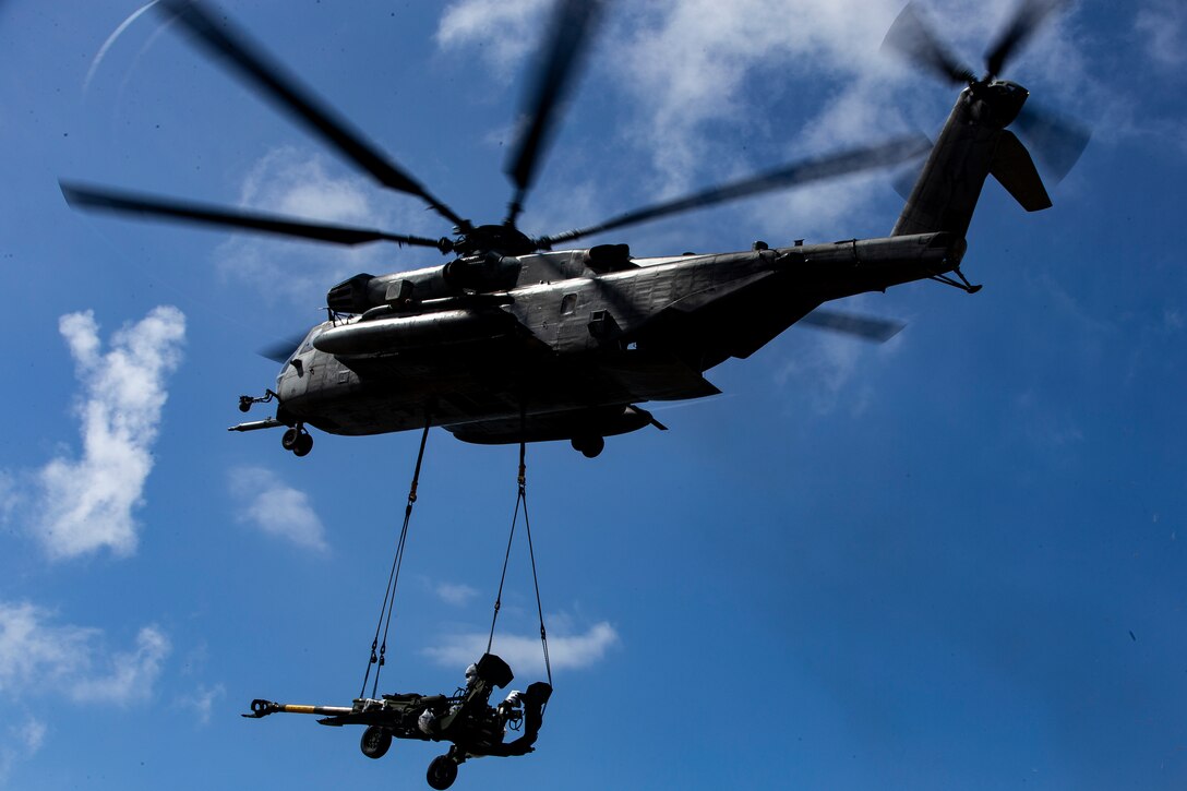 A U.S. Marine Corps CH-53E Super Stallion helicopter with Marine Heavy Helicopter Squadron 463 carries a M777A2 towed 155 mm howitzer during an amphibious landing demonstration at Pyramid Rock Beach as part of RIMPAC exercise on Marine Corps Base Hawaii July 29, 2018. RIMPAC provides high-value training for task organized, highly capable Marine Air-Ground Task Force and enhances the critical crisis response capability of U.S. Marines in the Pacific. Twenty-Five nations, 46 ships, five submarines, about 200 aircraft, and 25,000 personnel are participating in RIMPAC from June 27 to Aug. 2 in and around the Hawaiian Islands and Southern California.