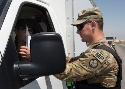 Military Police Investigator Joshua Higgins, 156th Military Police Law and Order Detachment, West Virginia Army National Guard, performs vehicle registration check and driver's documentation as part of random anti-terrorism measures on Bagram Airfield, Afghanistan, July 28, 2018. Members of the 156th Military Police Law and Order Detachment are deployed to both Bagram and Kandahar Airfields where they perform law and order operations for both installations.