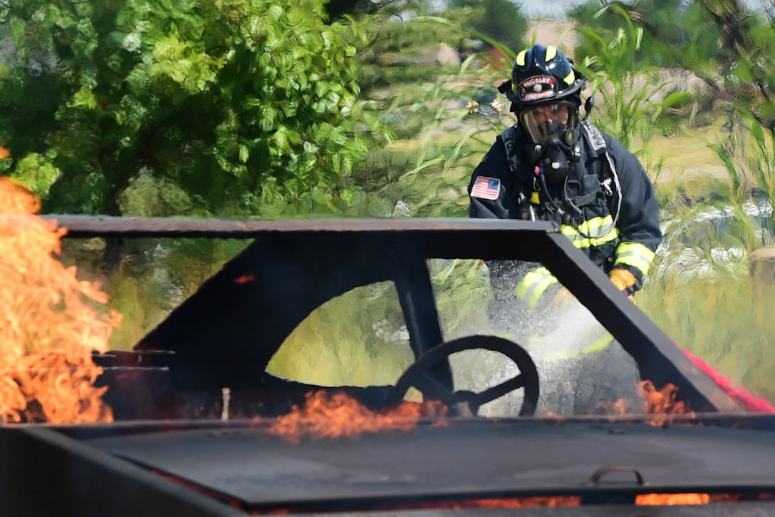 A firefighter extinguishes a car fire while training during Exercise Panther View.