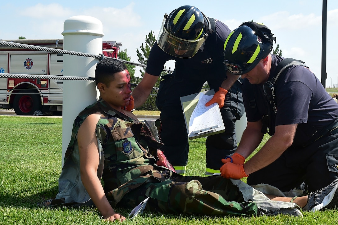 Firefighters perform self-aid buddy care on a "victim" from a simulated explosion.