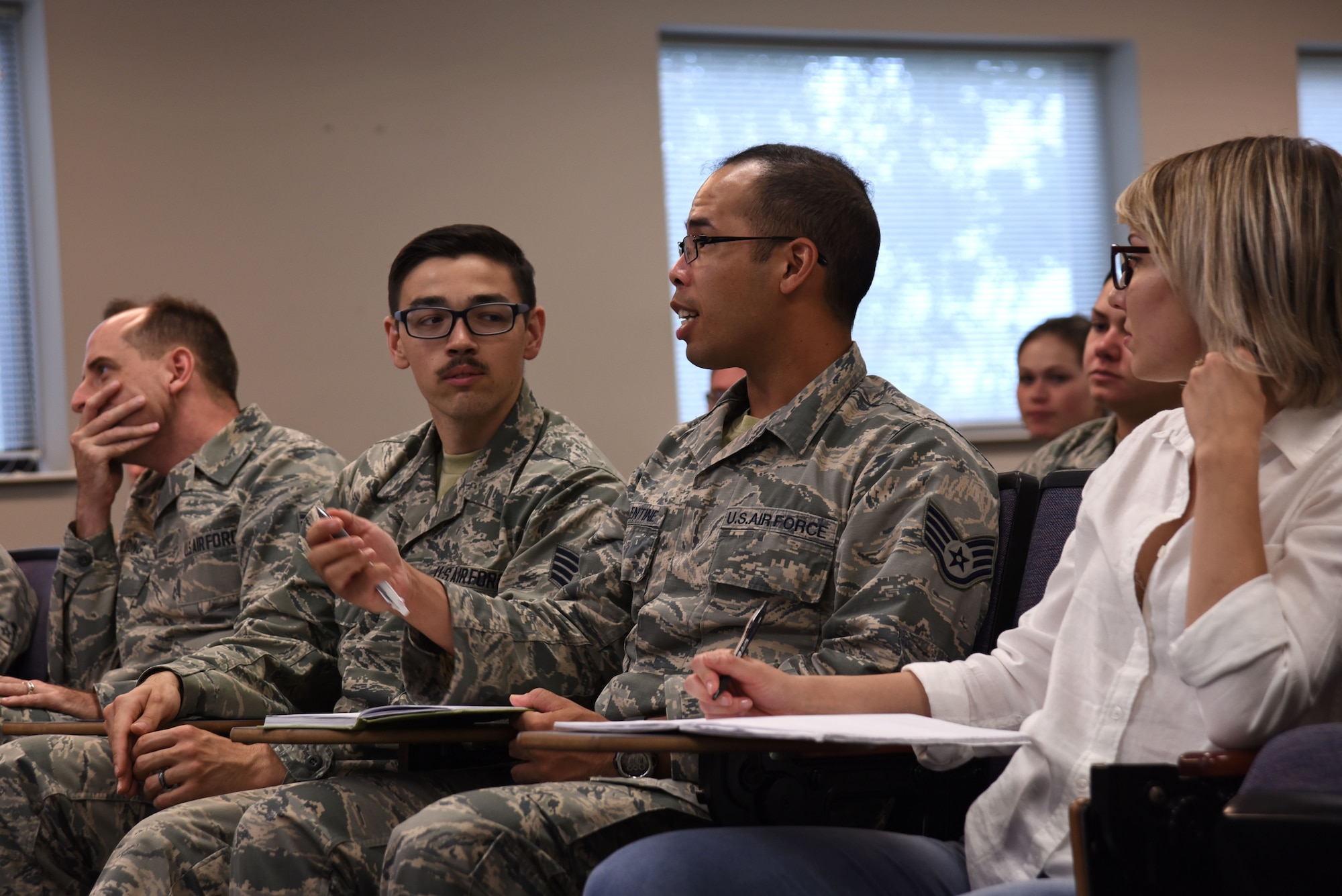 A U.S. Airman asks a question during a Headquarters Air Force Office of Special Investigations (AFOSI) recruiting team visit to the Spratt Education Center at Shaw Air Force Base, S.C., July 30, 2018.