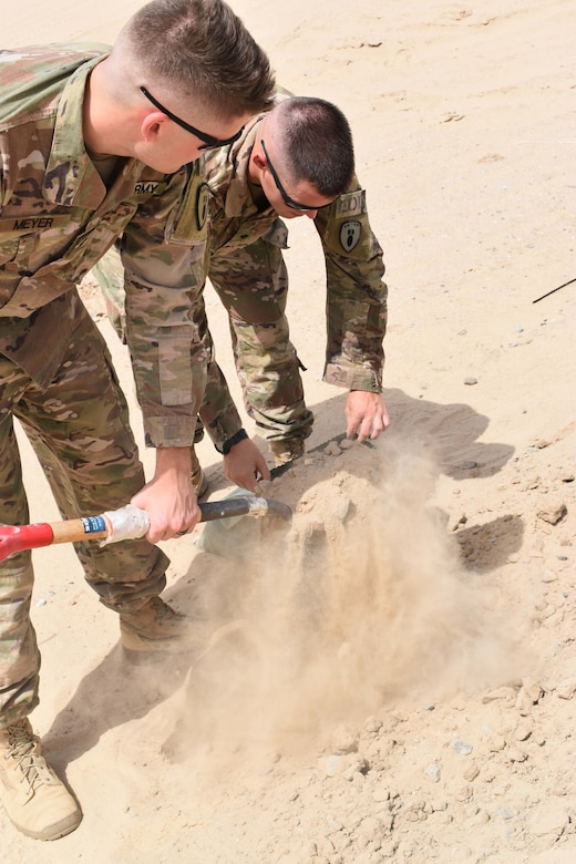 U.S. Army Spc. Zachary Meyer and U.S. Army Spc. Jonathon Peterson, 797th Explosive Ordnance Disposal Company, fill sandbags to be used in the transportation of a found UXO at Camp Arifjan, Kuwait, April 25, 2018.