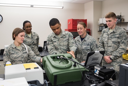 Tech. Sgt. Ashley Jordan, U.S. Air Force School of Aerospace Medicine Bioenvironmental Engineering Occupational Health Measurements Course director, second from right, instructs bioenvironmental engineering apprentice students on how to operate the HAPSITE ER portable gas chromatograph and mass spectrometer. The students are learning how to assemble the probe to the unit, install the gas canisters, install the battery, and prepare the system to identify and quantify trace amounts of an unknown substance that was captured from the air. (U.S. Air Force photo by Richard  Eldridge)