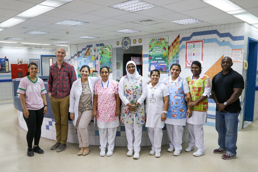 NBK children’s hospital staff and soldiers pose for a group photo during the Kuwait Association for the Care of Children in Hospital (KACCH) play therapy day through Task Force Spartan’s participation in the Every Soldier an Ambassador program.