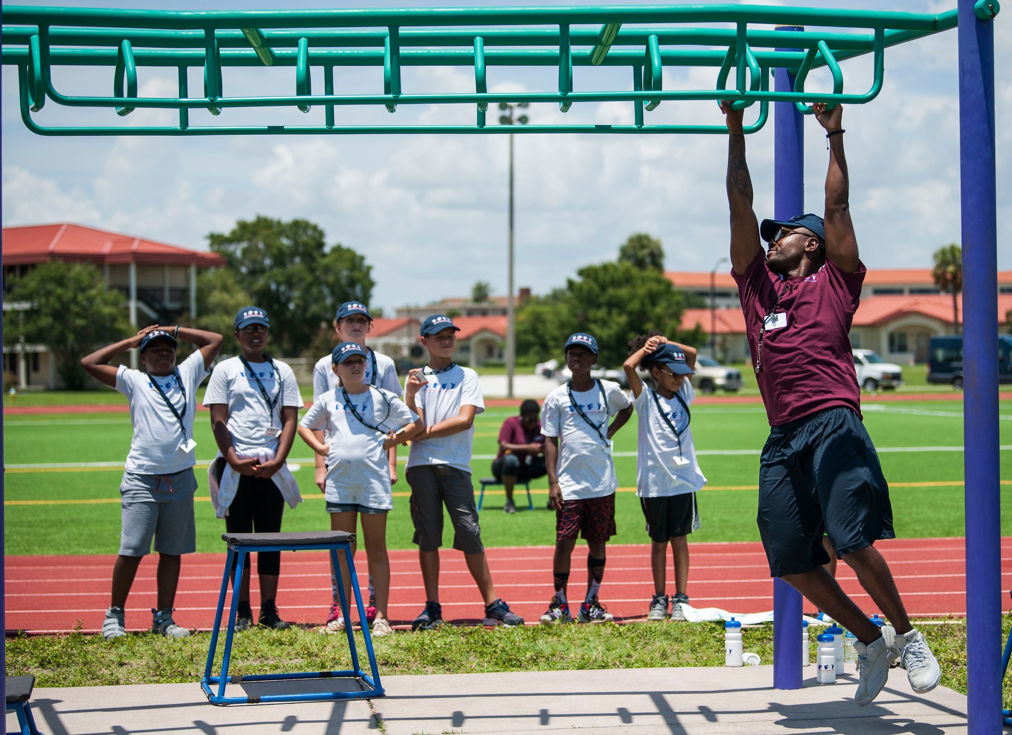 A Drug Education for Youth (D.E.F.Y.) volunteer demonstrates how to navigate an obstacle during a physical fitness session at MacDill Air Force Base, Fla., July 25, 2018.