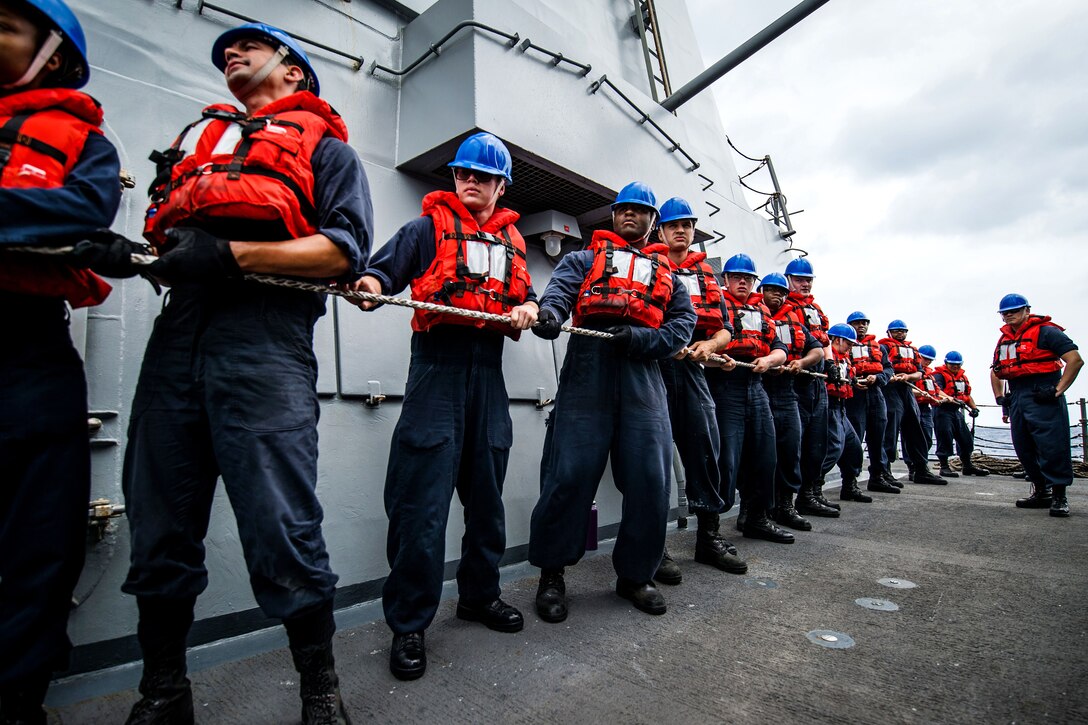 Sailors maintain positive control of a line during a replenishment-at-sea.